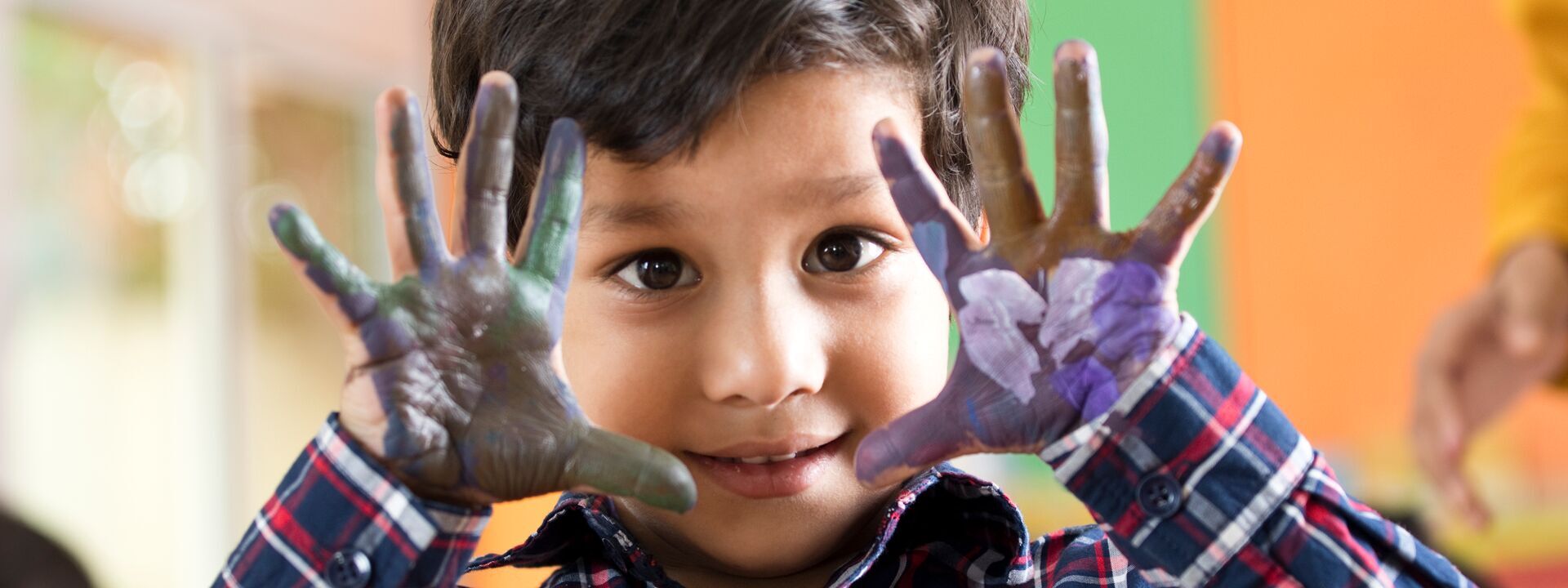 Preschool boy showing his painted palm of hands