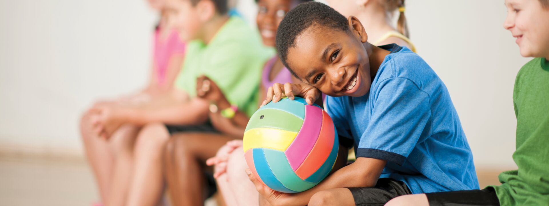 A boy with a volleyball on his lap at YMCA of Greater Charlotte