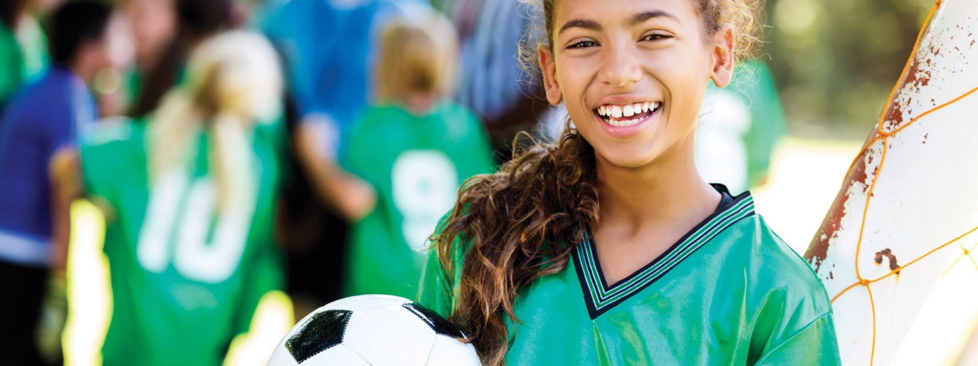 A girl with a soccer ball in her hand at YMCA recreational soccer