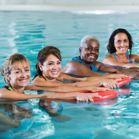 Four women participating in YMCA water fitness classes
